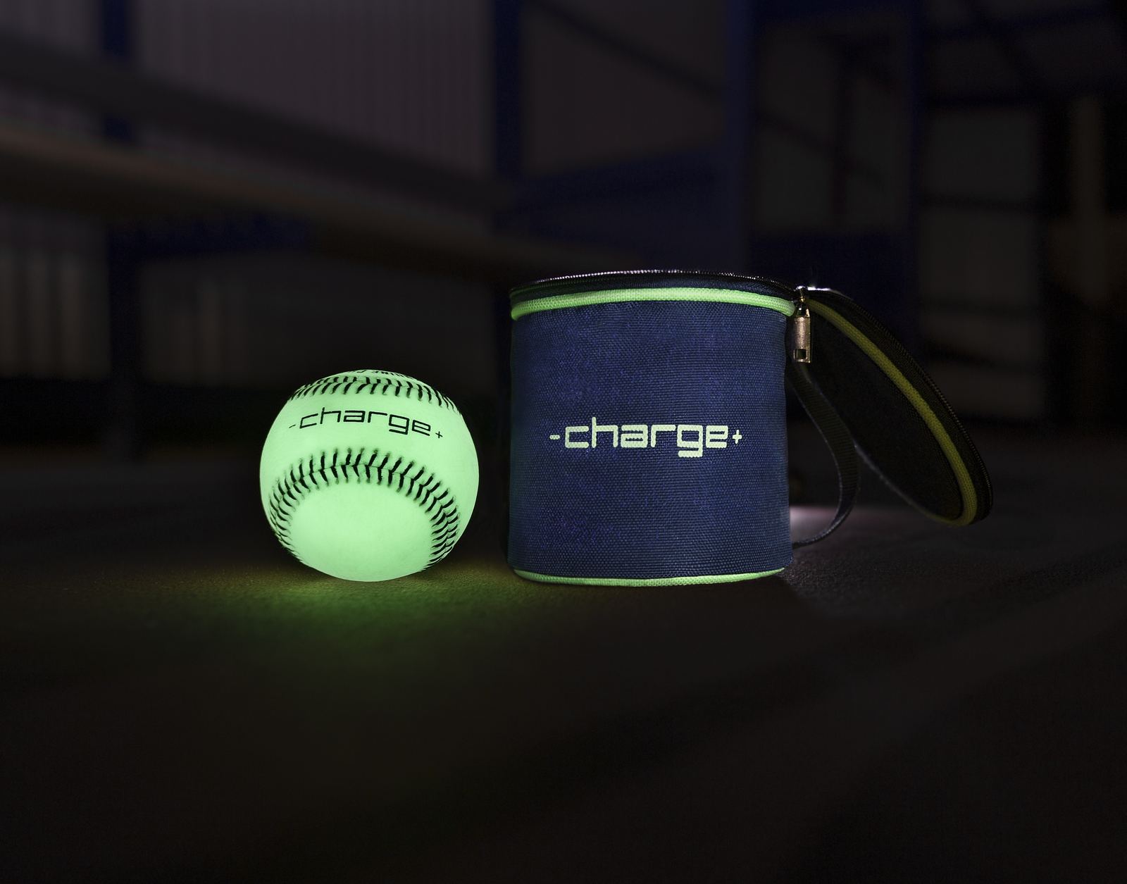 A glowing Chargeball beside the navy and green Chargebag, both stamped with the -charge+ wordmark